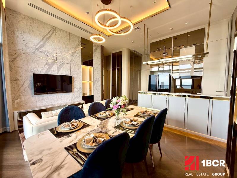 PENTHOUSE ONCE PATTAYA - Jedálenský stôl a obývacia izba v 4-izbovom byte s moderným interiérom.