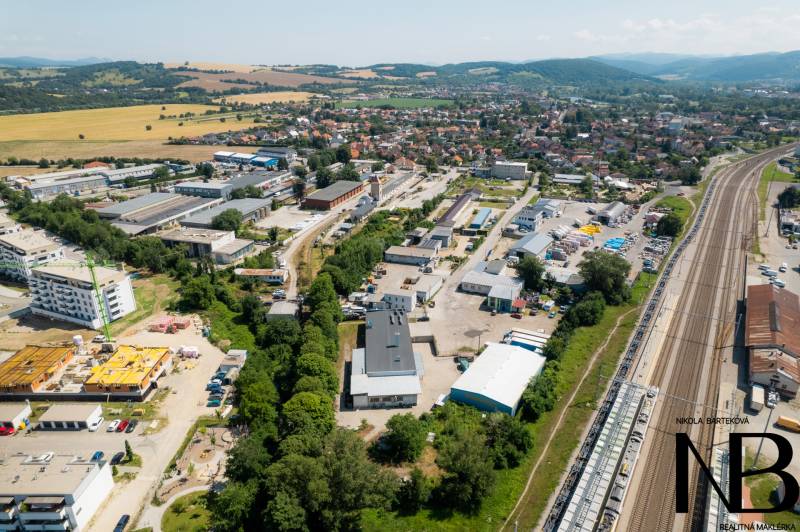 Na predaj polyfunkčný objekt na pozemku 4609 m2, TN - Zámostie - Letecký pohľad na priemyselnú oblasť na Kasárenskej ulici v Trenčíne so skladmi a halami.