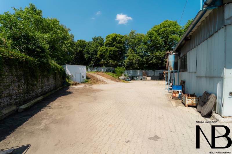 Na predaj polyfunkčný objekt na pozemku 4609 m2, TN - Zámostie - Spevnená plocha pri skladovej hale na Kasárenskej ulici v Trenčíne obklopená zeleňou.
