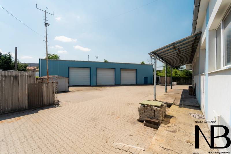 Na predaj polyfunkčný objekt na pozemku 4609 m2, TN - Zámostie - Sklady a haly na Kasárenskej ulici v Trenčíne so spevnenou plochou a modrou budovou.