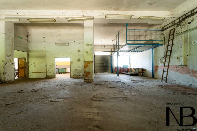 Na predaj polyfunkčný objekt na pozemku 4609 m2, TN - Zámostie - Opustené výrobné priestory so starými kovovými schodmi a opotrebovanou podlahou.