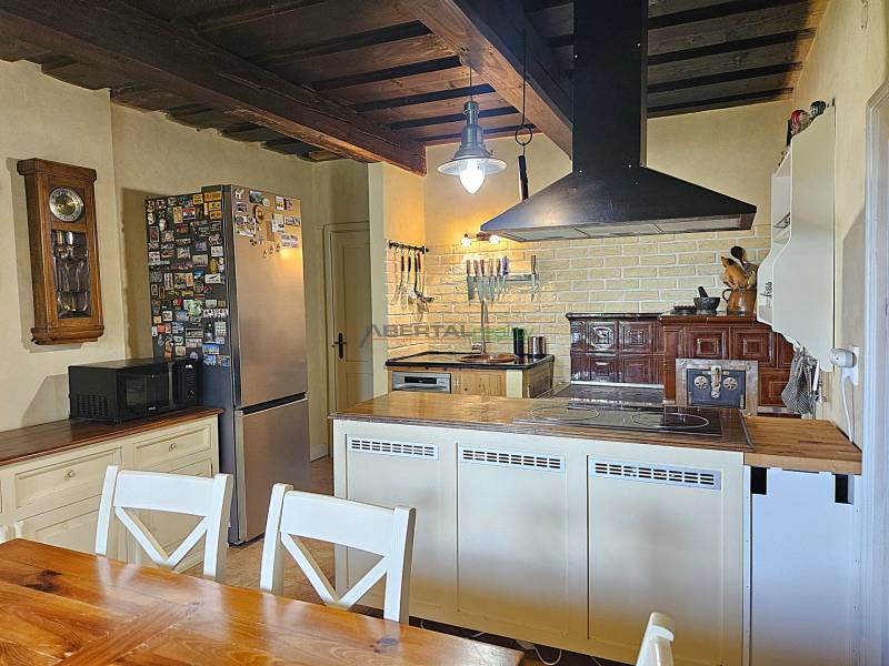 PREDAJ – Apartmánový dom na Donovaloch s 3 samostatnými apartmánmi - Kuchyňa v rodinnom dome s dreveným stropom, sporákom a masívnym stolom.