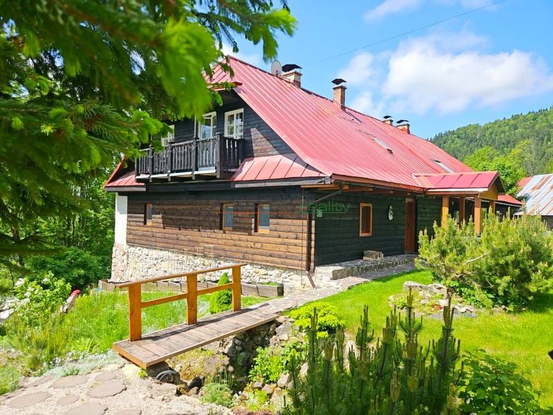 PREDAJ – Apartmánový dom na Donovaloch s 3 samostatnými apartmánmi - Rodinný dom v Donovaloch s drevenou fasádou a červenou strechou v prírodnom prostredí.