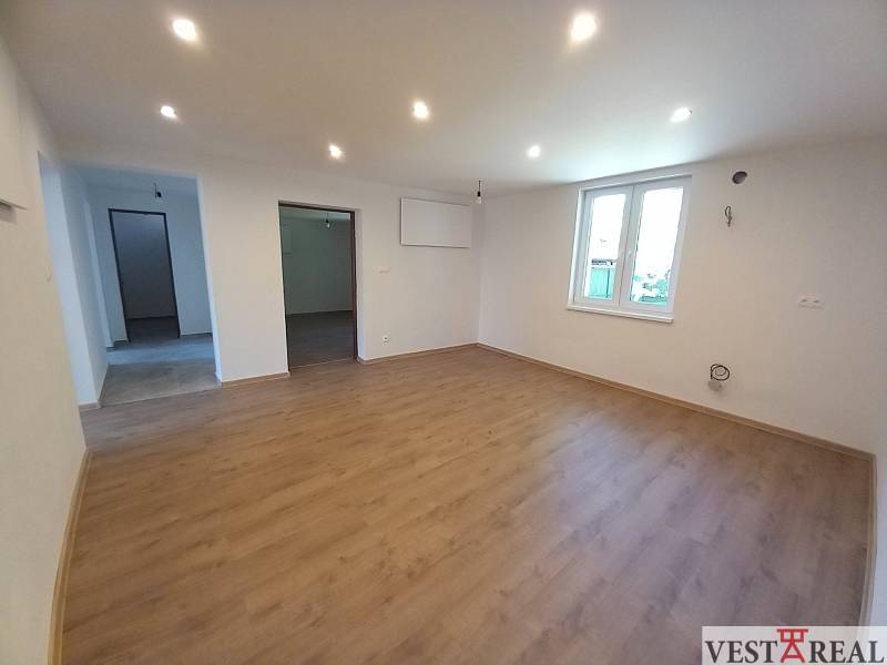 Na predaj zrekonštruovaný rodinný dom - Trakovice - Obývačka v rodinnom dome s drevenou podlahou a bielymi stenami.