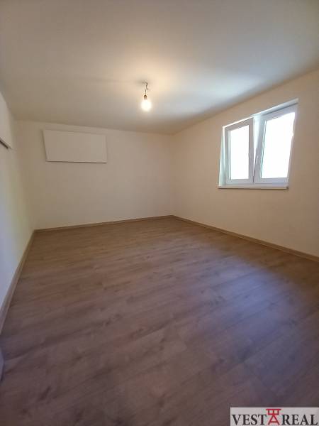 Na predaj zrekonštruovaný rodinný dom - Trakovice - Prázdna miestnosť s laminátovou podlahou a bielymi stenami v rodinnom dome.