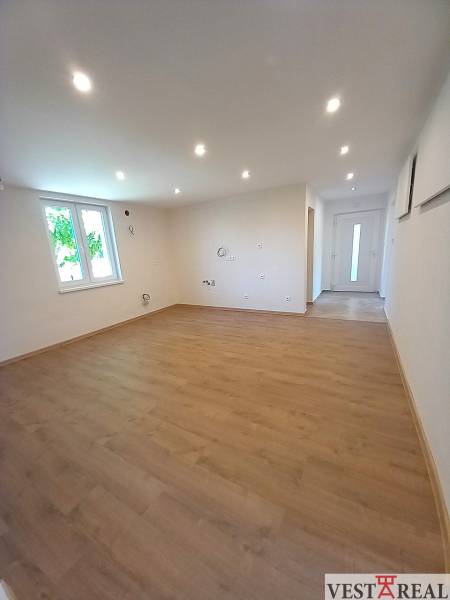Na predaj zrekonštruovaný rodinný dom - Trakovice - Priestranná izba s laminátovou podlahou a bodovými svetlami v rodinnom dome.