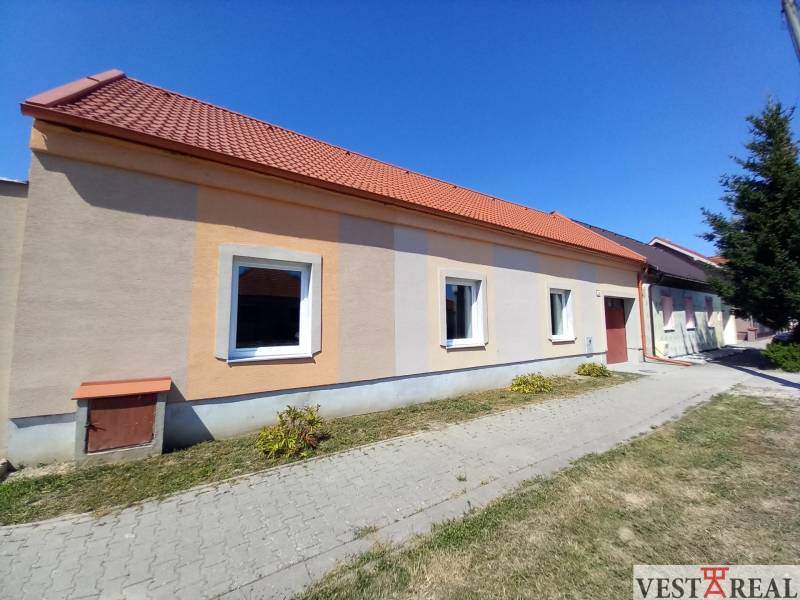 Na predaj zrekonštruovaný rodinný dom - Trakovice - Rodinný dom v Trakoviciach s oranžovou fasádou a červenou strechou.