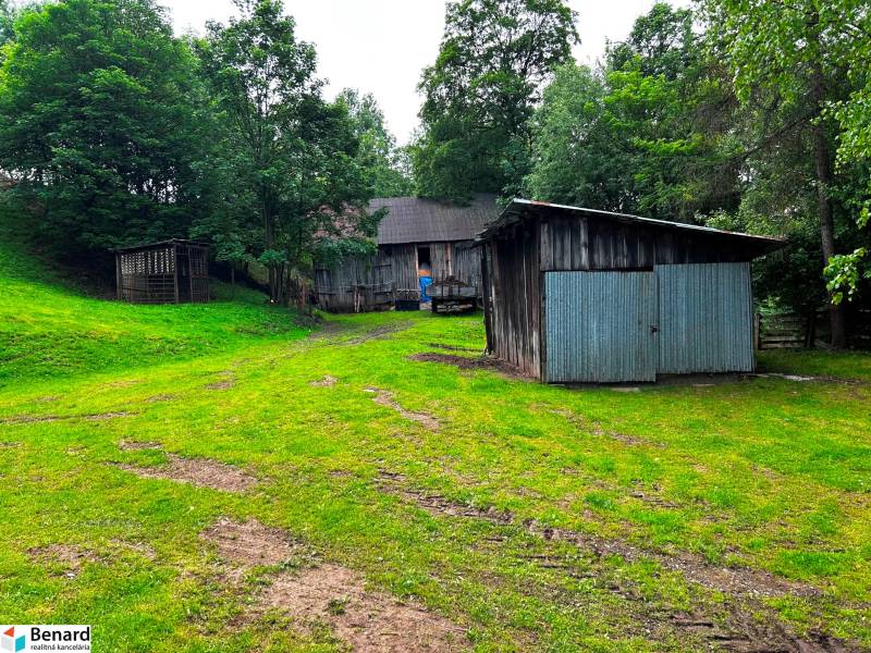 STARŠÍ RODINNÝ DOM, POZEMOK 2476 m2, VEĽKÁ LESNÁ; - Rodinný dom v Veľkej Lesnej s drevenými prístreškom obklopený zeleňou a stromami.