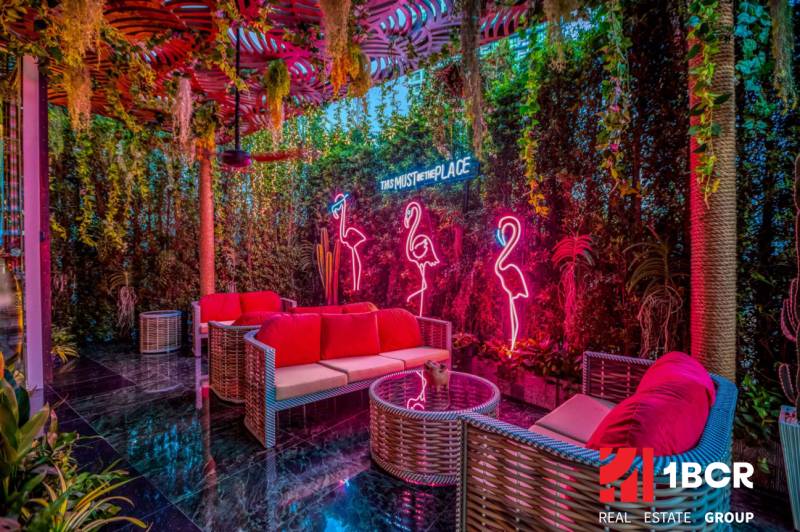 THE RIVIERA OCEAN DRIVE PATTAYA - Interiér s neónovými svetlami, prútený nábytok, zeleň a svetelné dekorácie vo Výstavbe bytov.