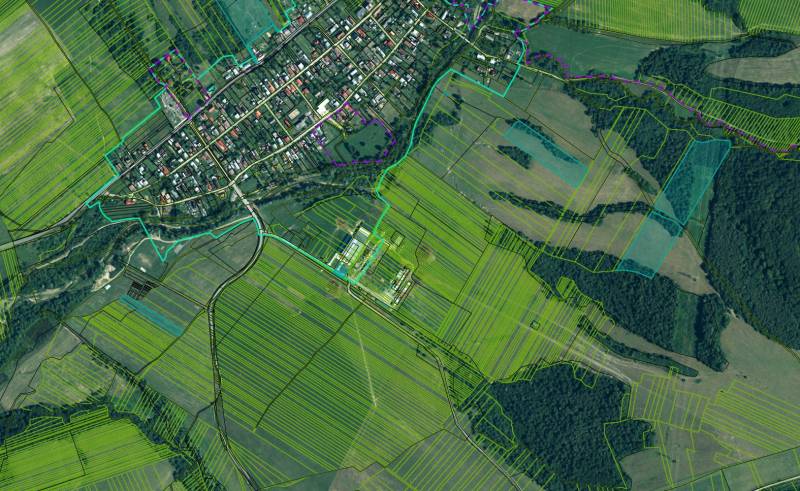 Ladomirová – 13.193 m2 POZEMKY v pozemkových úpravách - Ladomirová s poľnohospodárskymi a lesnými pozemkami, ukazujúca dedinu a okolité polia.