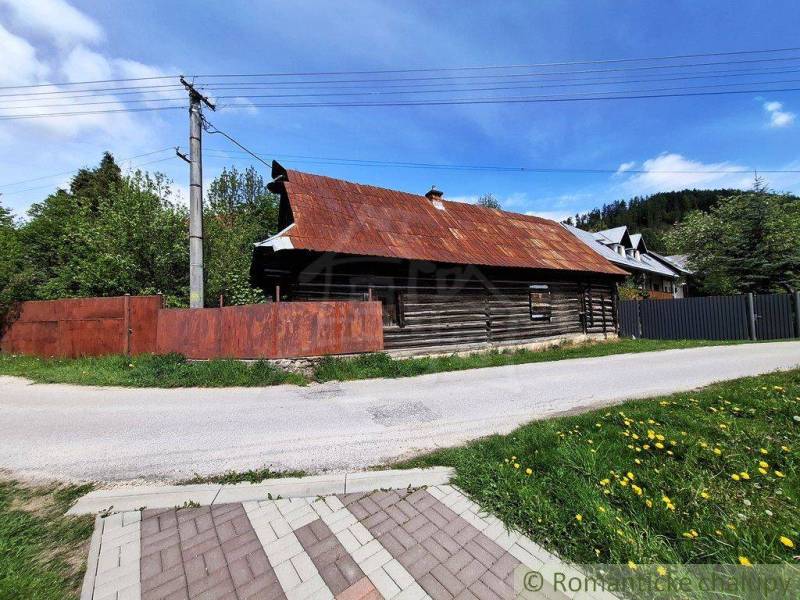 Súbor nehnuteľností určených na revitalizáciu Pohorelá -Nízke Tatry - Rodinný dom v Pohorelej s drevenou konštrukciou, vedľa cesty a zelene.