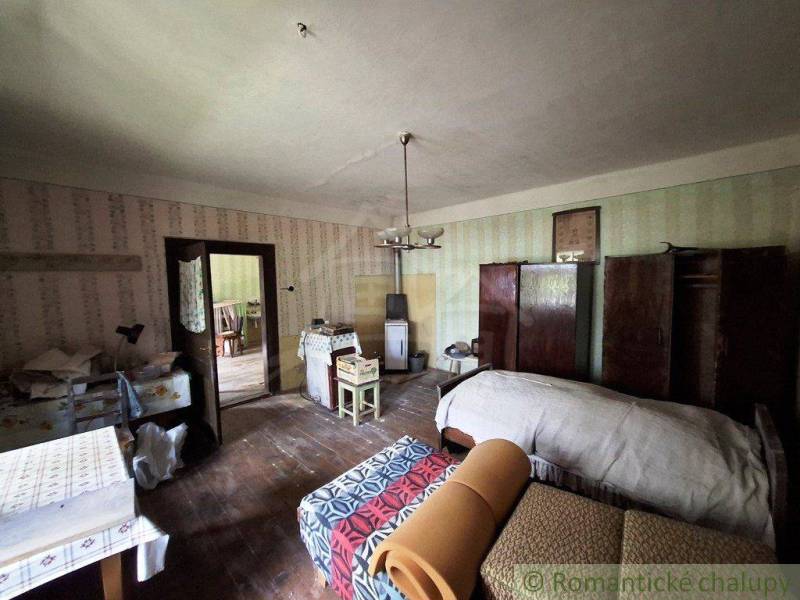 Súbor nehnuteľností určených na revitalizáciu Pohorelá -Nízke Tatry - Izba v rodinnom dome s posteľou, nábytkom a klasickou výzdobou.