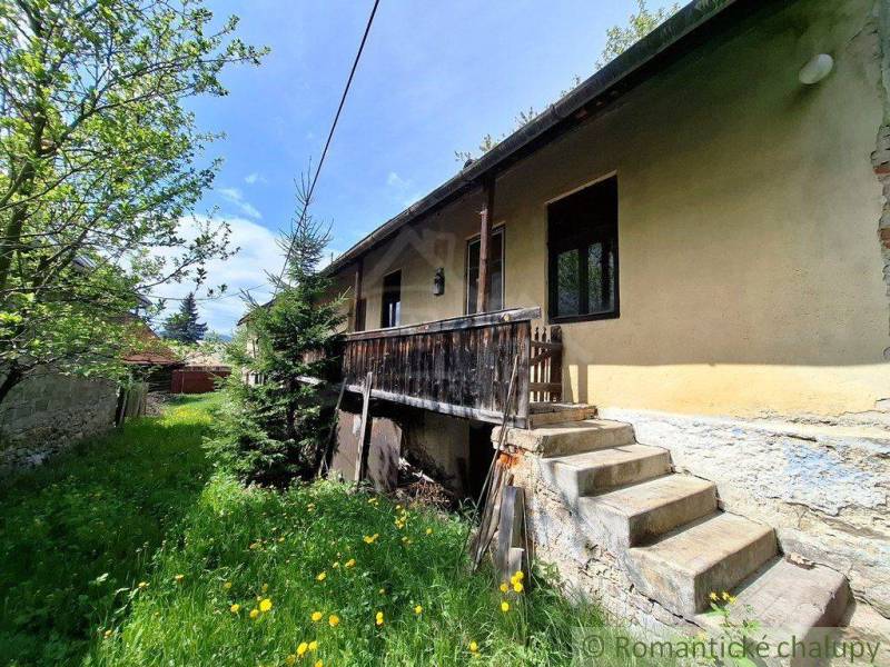 Súbor nehnuteľností určených na revitalizáciu Pohorelá -Nízke Tatry - Rodinný dom v Pohorelej s drevenou terasou, schodmi a trávnatým pozemkom s kvetmi.