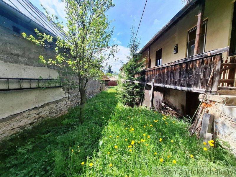 Súbor nehnuteľností určených na revitalizáciu Pohorelá -Nízke Tatry - Rodinný dom v Pohorelej, trávnatý dvor s kvetmi a stromami, drevená veranda.