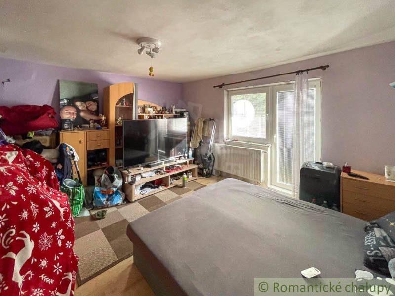 Rodinný dom so slnečnou záhradou v obci Sielnica, okres Zvolen - Obývačka v rodinnom dome so pohovkou, televízorom a dekoráciami na stene.