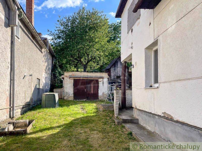 Rodinný dom so slnečnou záhradou v obci Sielnica, okres Zvolen - Dvor rodinného domu v Sielnici s prístreškom a stromom na pozadí.