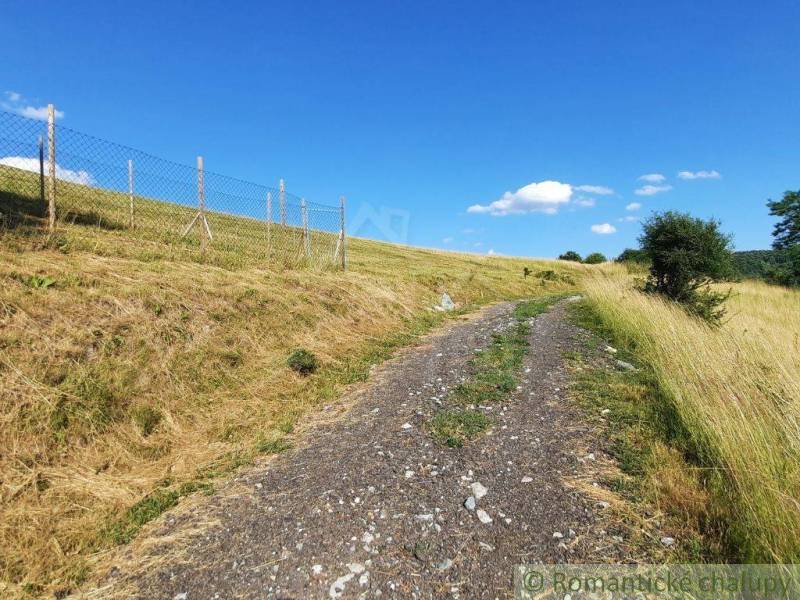Na predaj slnečný pozemok 5854 m² – Župkov, tichá lokalita s výhľadom - Poľná cesta v Záhradách v Žarnovici, obklopená trávnatými svahmi a plotom.