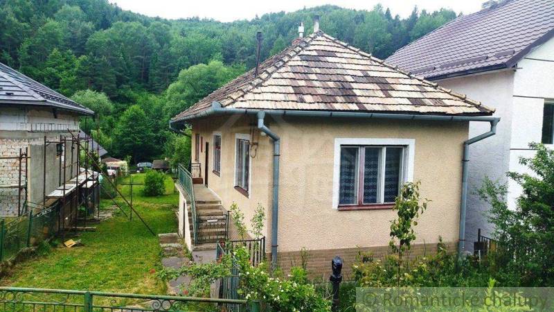 Útulný vidiecky domček, Fričovce - Rodinný dom vo Fričovciach, obklopený zeleňou, so záhradou a kopcovitým pozadím.