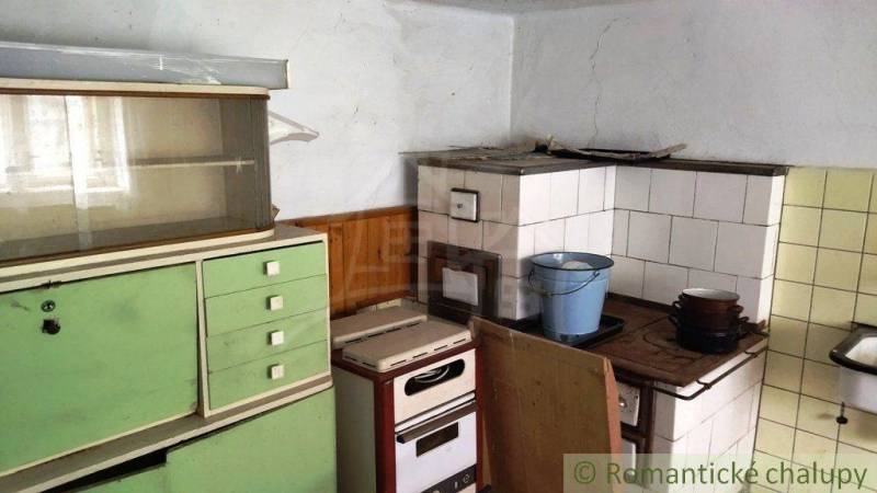 Útulný vidiecky domček, Fričovce - Kuchyňa s tradičným kredencom a pecou v rodinnom dome, retro štýl.
