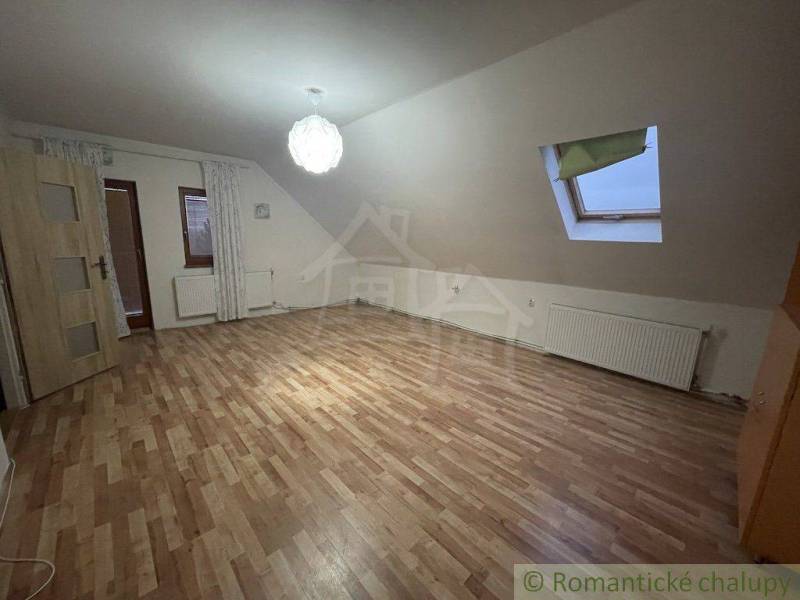 Zrekonštruovaný rodinný dom v tichej lokalite v obci Palárikovo - Podkrovná izba v rodinnom dome s laminátovou podlahou a strešným oknom.