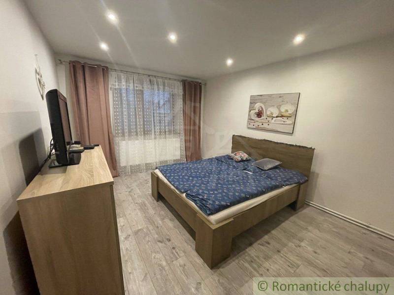 Zrekonštruovaný rodinný dom v tichej lokalite v obci Palárikovo - Spálňa s manželskou posteľou, televízorom a obrazom, súčasť rodinného domu.