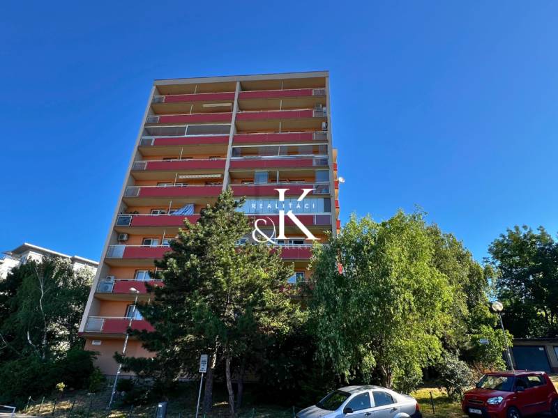 2 i byt s loggiou, balkónom a pivnicou, Ladzianskeho, Kramáre BA III - Výškový bytový dom na ulici Ladzianskeho, Bratislava - Vinohrady, obklopený zeleňou a autami.