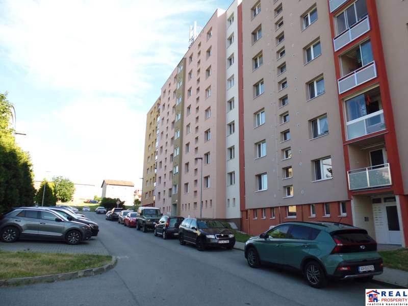 3-izb. byt s loggiou: KOMPLET ZARIADENÝ a ZREKONŠTR., 65 m2 - Lomnická - Ulica Lomnická v Prešove s bytovými domami a zaparkovanými autami, 3-izbový byt.