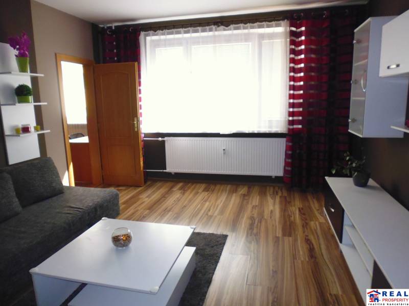 3-izb. byt s loggiou: KOMPLET ZARIADENÝ a ZREKONŠTR., 65 m2 - Lomnická - Obývacia izba v 3-izbovom byte s pohovkou, stolíkom a závesmi na okne.