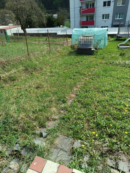  Na predaj 3-izbový byt s podkrovím, garážou a záhradou – Nová Baňa   - Záhrada pri dome na ulici Cintorínska, blízko trojizbového bytu, s trávnatým pozemkom.