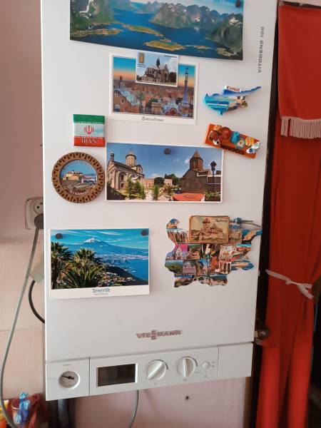  Na predaj 3-izbový byt s podkrovím, garážou a záhradou – Nová Baňa   - Na bielej stene visia pohľadnice a magnetky, popisujú viaceré turistické destinácie.
