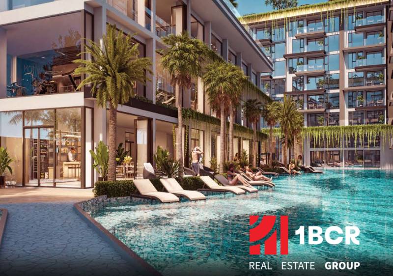 THE RIVIERA BEVERLY HILLS RESIDENCES PATTAYA - Výstavba bytov v Pattayi s bazénom a ležadlami obklopenými palmami a rastlinami.