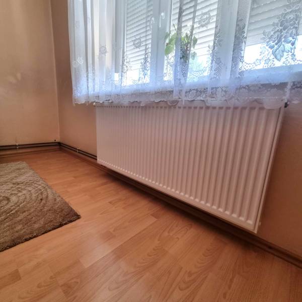 Rodinný dom na predaj - Malacky. - Izba s radiátorom pod oknom a závesom v rodinnom dome.