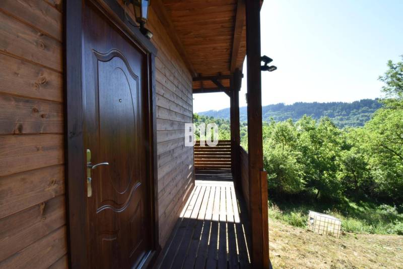 Predaj chaty a chalupy, Bytča - Chata pri Bytči s drevenou terasou obklopená zelenou prírodou a lesmi.