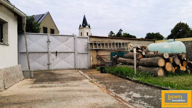 Predaj rodinného domu, Neusiedl am See - Vstupný dvor rodinného domu v 2473 Potzneusiedli s bránou a naskladaným drevom.