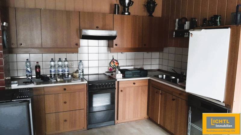 Predaj rodinného domu, Neusiedl am See - Kuchyňa v rodinnom dome s drevenými skrinkami a bielymi kachličkami.