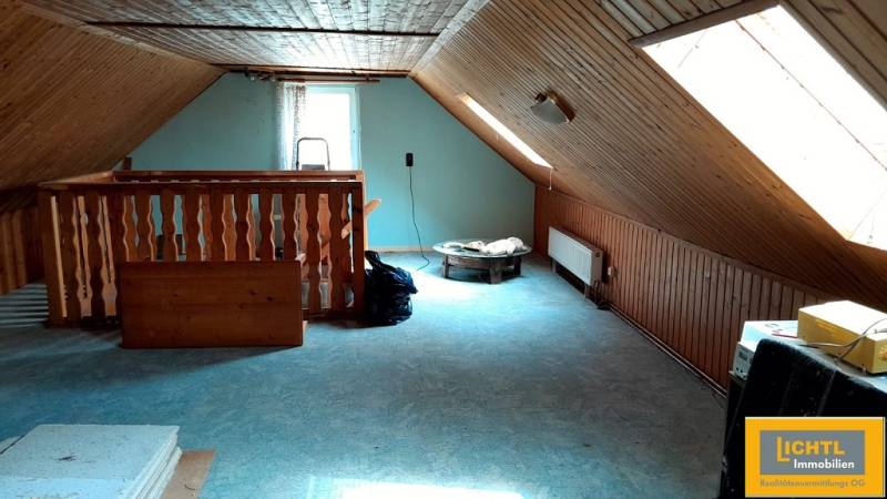Predaj rodinného domu, Neusiedl am See - Podkrovná miestnosť so strešnými oknami a dreveným obkladom v rodinnom dome.
