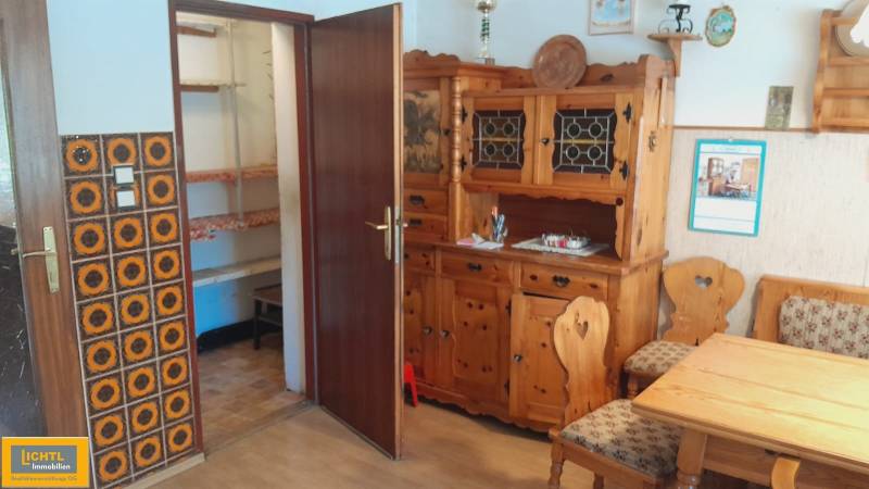 Predaj rodinného domu, Neusiedl am See - Drevený nábytok v interiéri rodinného domu s ornamentálnym obkladom steny.