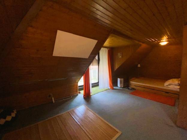Predaj rodinného domu, Bruck an der Leitha - Podkrovná izba v rodinnom dome s dreveným obložením a posteľou po pravej strane.