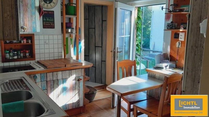 Predaj rodinného domu, Neusiedl am See - Kuchyňa v rodinnom dome s dreveným nábytkom a priamym vstupom na terasu.