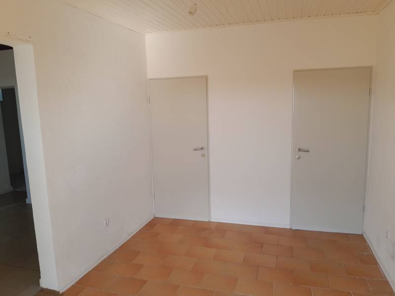 Prenájom obchodného priestoru, Neusiedl am See - Interiér obchodných priestorov s dvoma bielymi dverami a dlažbou.