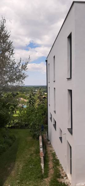 Predaj vily, Bruck an der Leitha - Biela fasáda vily v Hainburgu an der Donau s výhľadom na záhradu a stromy.