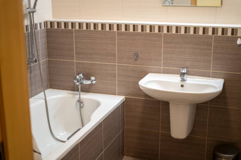 Vkusne zrekonštruovaný 3-izbový byt - Karadžičova ulica, Bratislava - Kúpeľňa s umývadlom a vaňou v 3-izbovom byte, decentné obklady stien.