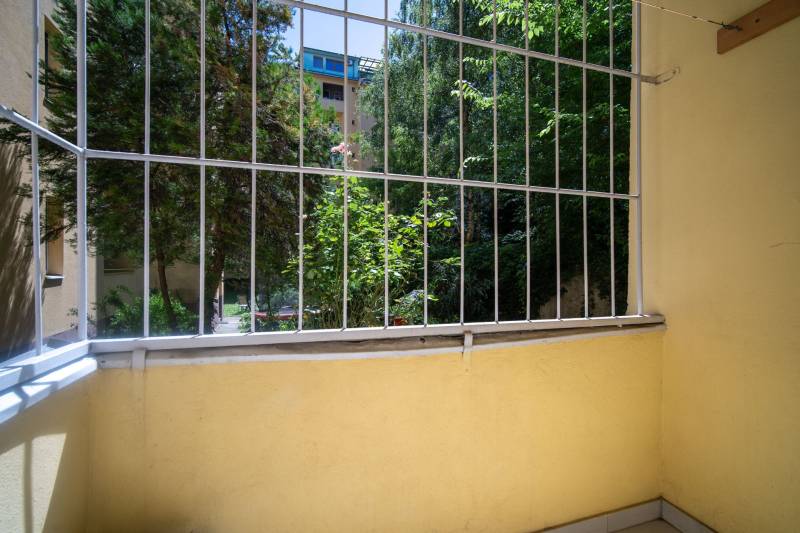 Vkusne zrekonštruovaný 3-izbový byt - Karadžičova ulica, Bratislava - Malý balkón s výhľadom na zeleň a drevené prvky v 3-izbovom byte.