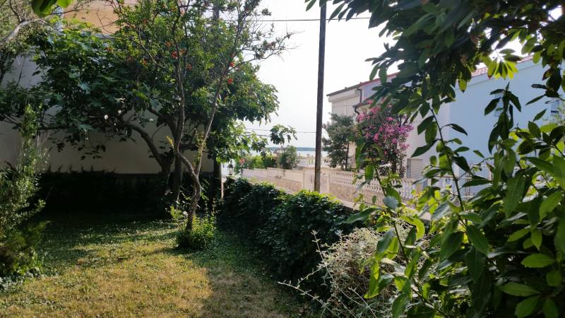 CHORVÁTSKO - 2. rad od mora - apartmánový dom - VRSI, Zadar - Záhrada rodinného domu vo Vrsi s výhľadom na more medzi zeleňou.
