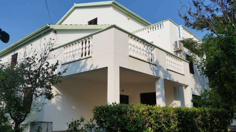 CHORVÁTSKO - 2. rad od mora - apartmánový dom - VRSI, Zadar - Rodinný dom vo Vrsi s bielym balkónom a zeleňou v okolí.