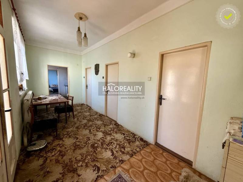 Predaj, rodinný dom Padarovce - EXKLUZÍVNE HALO REALITY - Interiér rodinného domu s chodbou, stolom, stoličkami a kobercom.