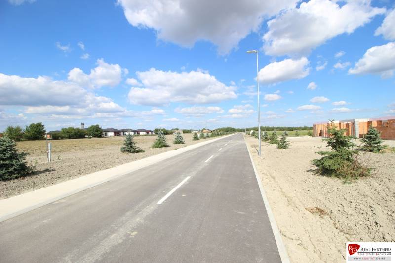 Luxusná veľkometrážna parcela za skvelú cenu Kvetoslavov,2480m2 - Cesta na ulici so stromami, obloha s oblakmi, Lesopark a pozemky na bývanie.