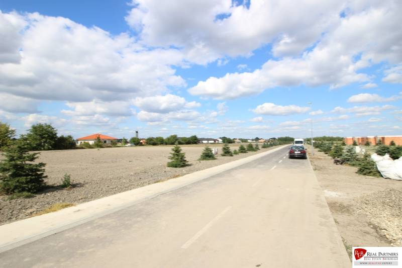 Luxusná veľkometrážna parcela za skvelú cenu Kvetoslavov,2480m2 - Ulica s áutami a stromami v pozadí, vhodná pre bývanie na Lesopark.