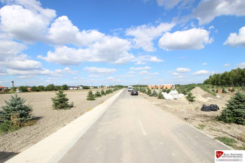 Luxusná veľkometrážna parcela za skvelú cenu Kvetoslavov,2480m2 - Po asfaltovej ceste vedúcej na ulici Lesopark, lemovanej malými stromami, vidieť pozemky - bývanie.