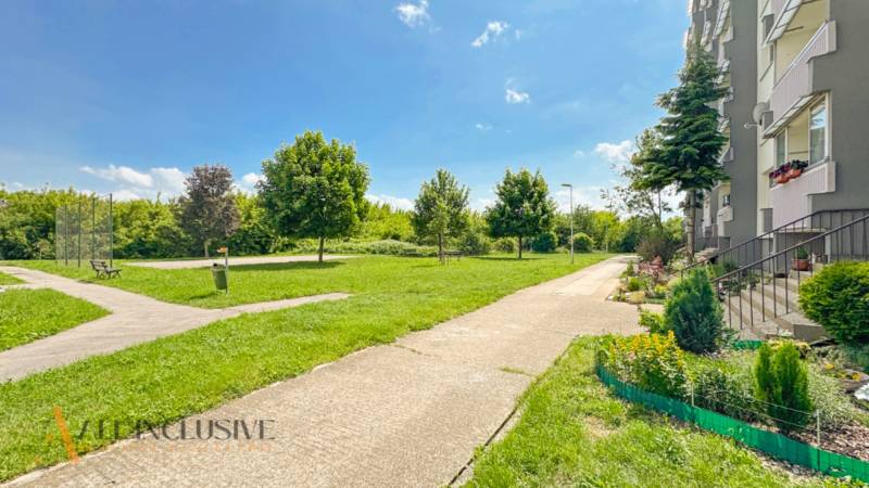 PRIESTRANNÝ 3 IZBOVÝ BYT | TOPOĽČANY | STREĎANSKÁ - Zelený park so stromami vedľa bytovky na Streďanskej ulici v Topoľčanoch.